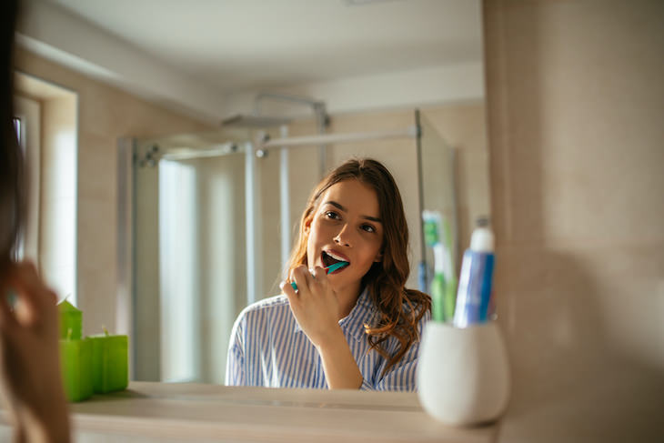 Why Brushing Teeth BEFORE Your Morning Coffee Is Essential, woman brushing teeth
