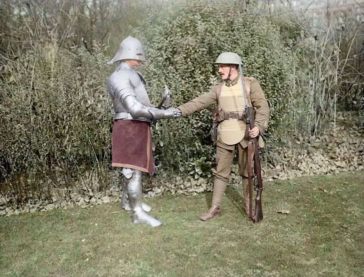 Rare and Beautifully Colorized Historical Photo Comparison between a British WWI veteran soldier armed with a rifle with a soldier in a full suit of medieval armor handling an ax, October 1917