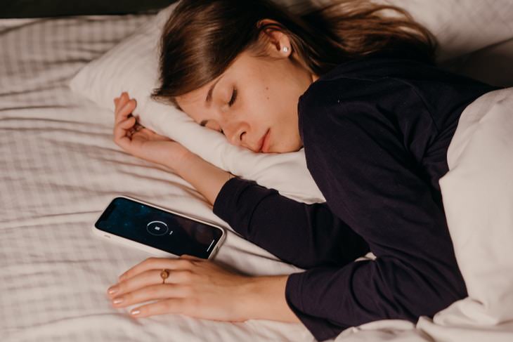 how to get back to sleep when you wake up at night woman sleeping next to a phone
