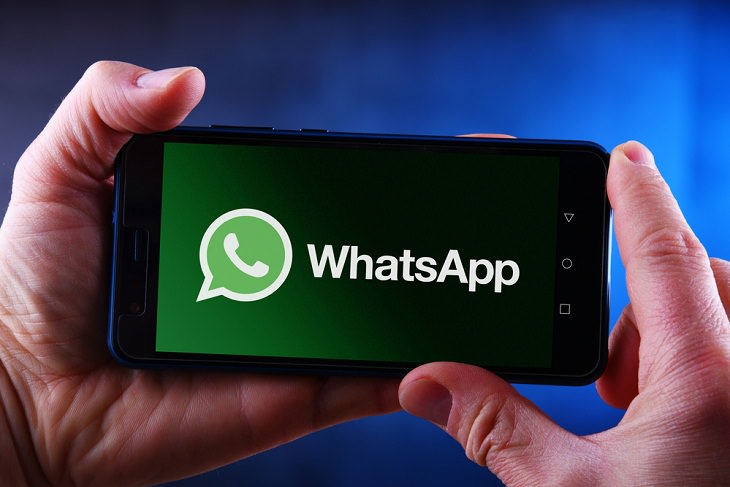 Free Up Storage Space on WhatsApp, holding phone
