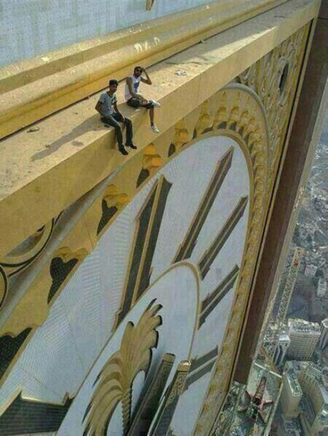 Comparison Photos Two people sitting on the Abraj Al Bait clocktower in Mecca.