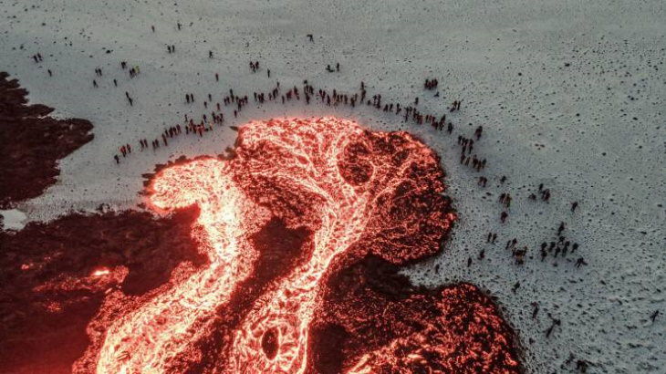 Poignant Photos People gathering around molten lava in Iceland