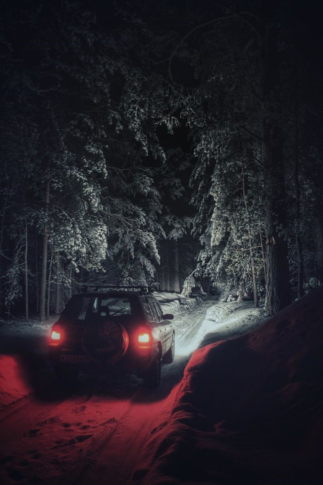 Amazing Places snow-covered forest and car at night 