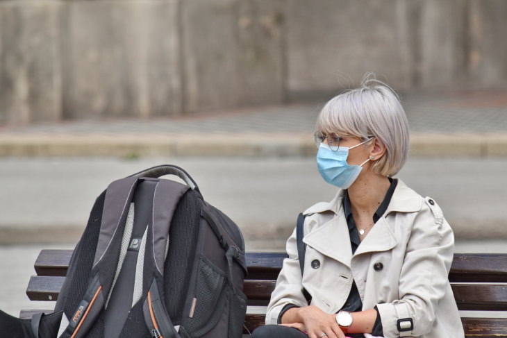 How to Travel Safely in 2021 woman in mask near backpack