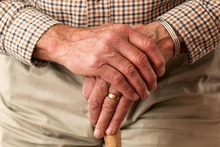 Stages of Parkinson’s Disease hands of older man with cane