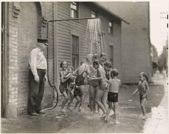 Children cooling off outside a firehouse, 1935