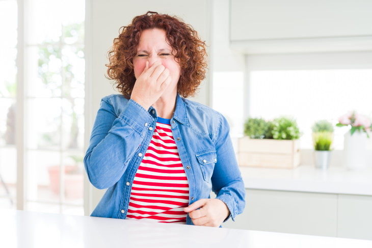 Migraine Prodrome Signs woman smelling something unpleasant