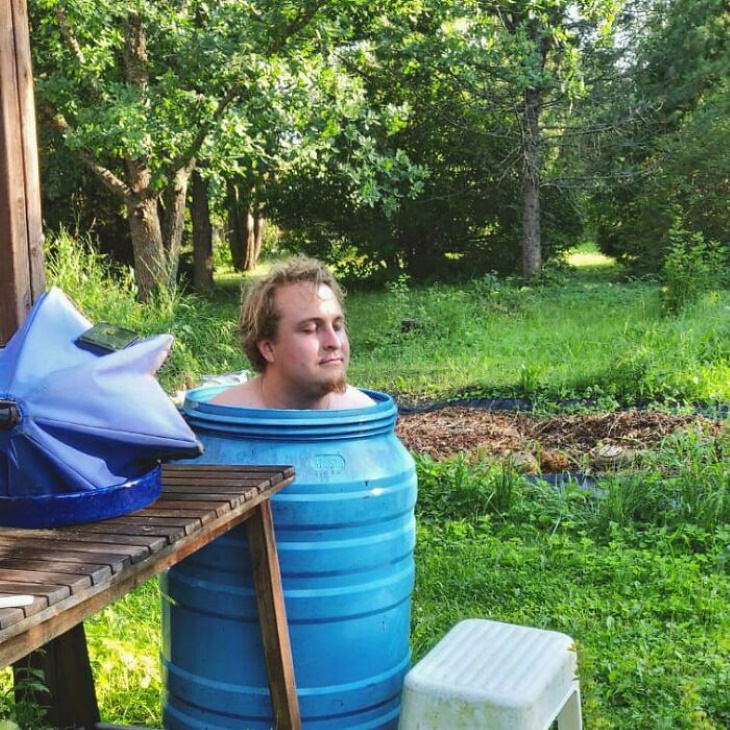 Heatwave man sitting in a barrel of water