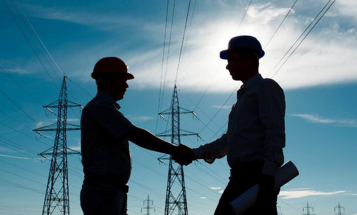 2 electricity professionals shaking hands