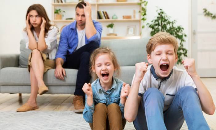 two children yelling, parents upset on the couch