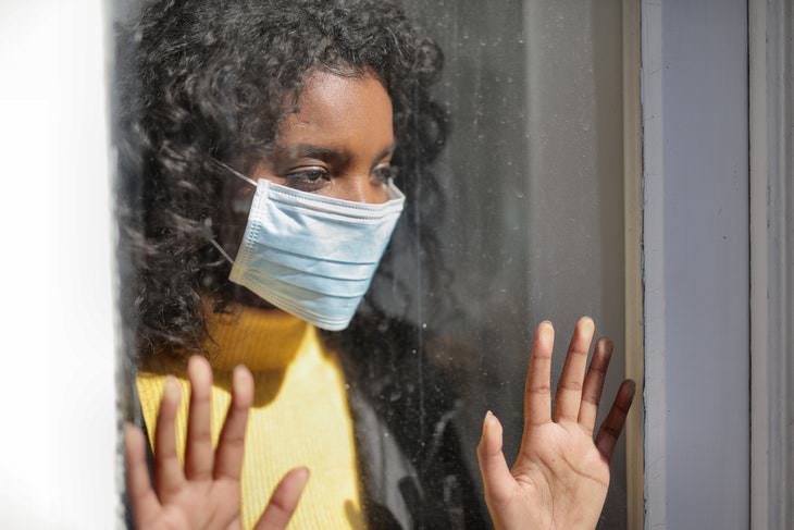 Flurona woman in face mask near the window