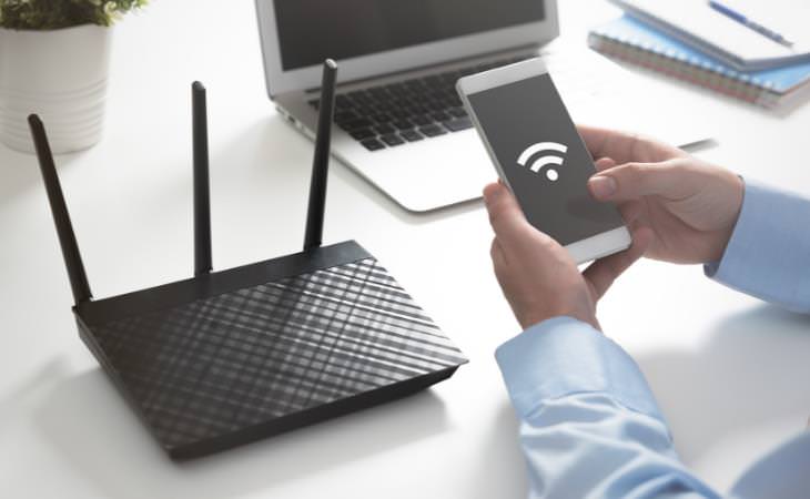  Router y modem, router negro en la mesa de la oficina con un smartphone