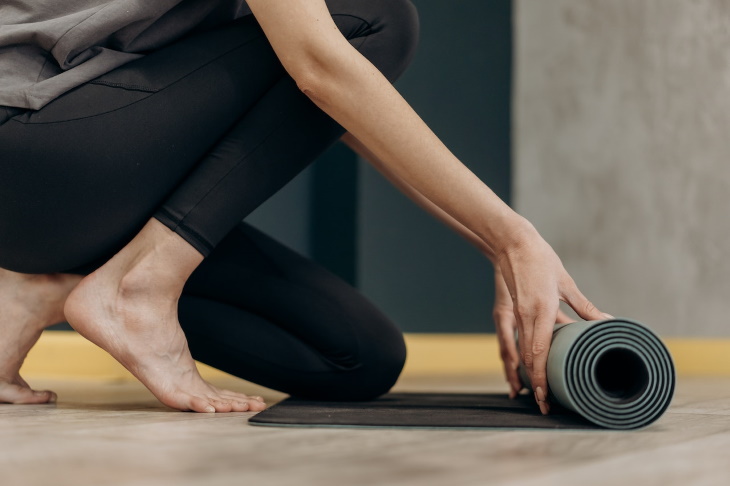 Yoga For Diabetes woman unrolling a yoga mat