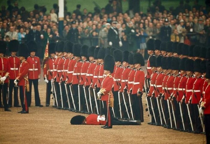 Soldados britânicos impassíveis enquanto um dos guardas desmaia (Londres, junho de 1966)