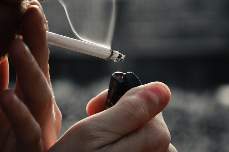 Cómo Prevenir La Acidez Estomacal, hombre encendiendo un cigarrillo