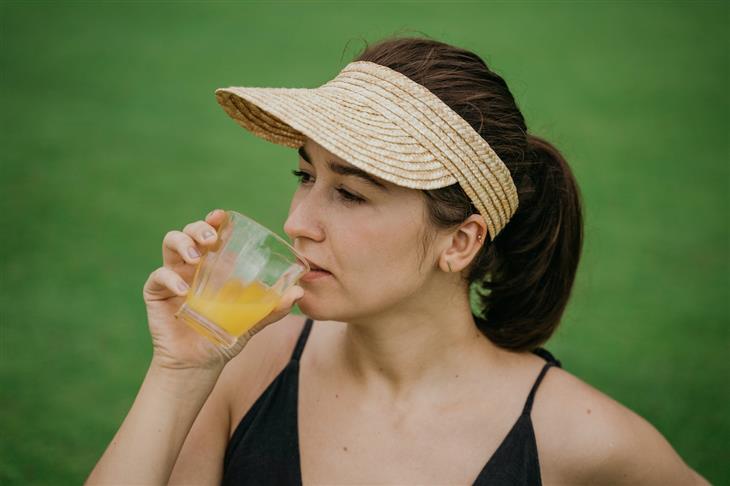 Cómo Prevenir La Acidez Estomacal, mujer bebiendo jugo de naranja