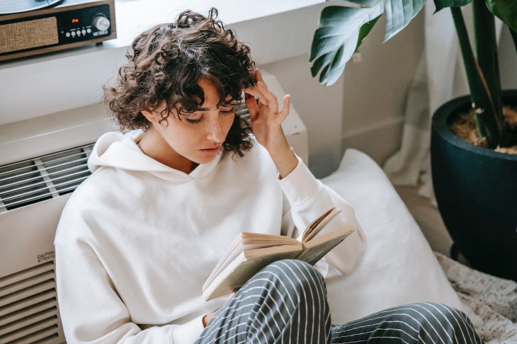 Cómo Prevenir La Acidez Estomacal, mujer leyendo un libro
