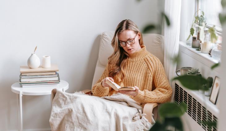 woman reading a book on a cozy couch