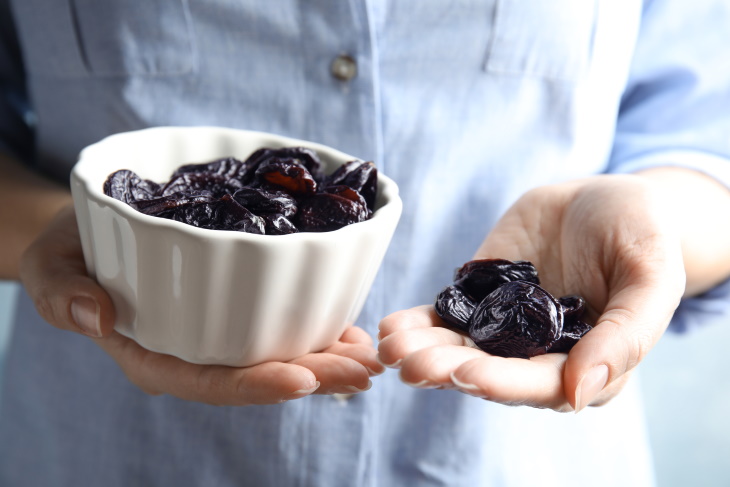 Prunes for Osteoporosis woman holding prunes in hands