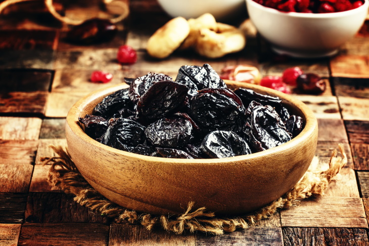 Prunes for Osteoporosis a wooden bowl with prunes