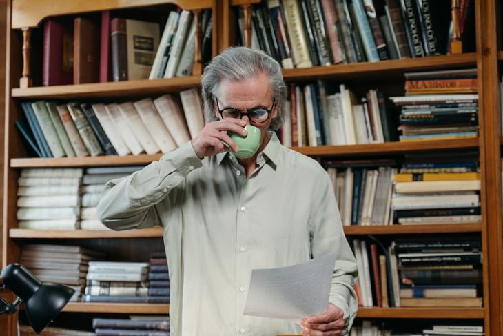 Will Mistakes man reading document and drinking coffee