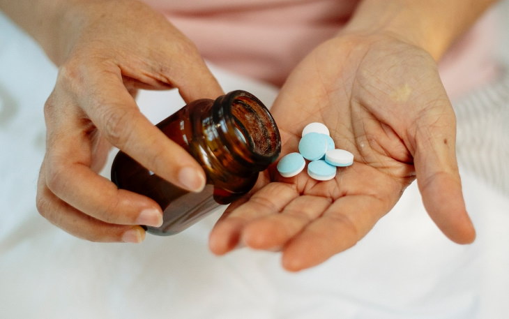 unnecessary supplements pouring a handful of pills out of the bottle