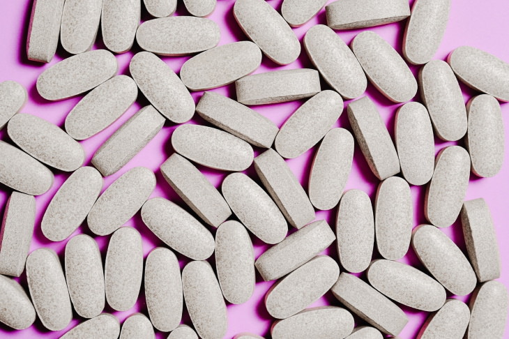 unnecessary supplements pills on a pink background