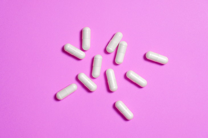 unnecessary supplements capsules on a pink background