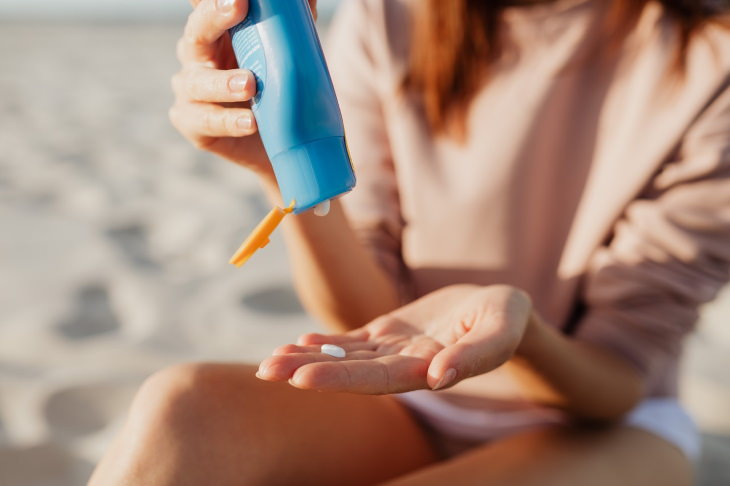 Sunscreen Stain Removal woman applying sunscreen on beach