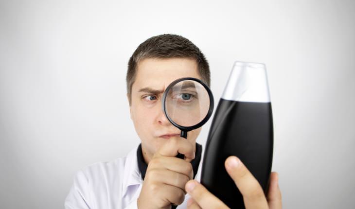 man reading label on a shampoo bottle