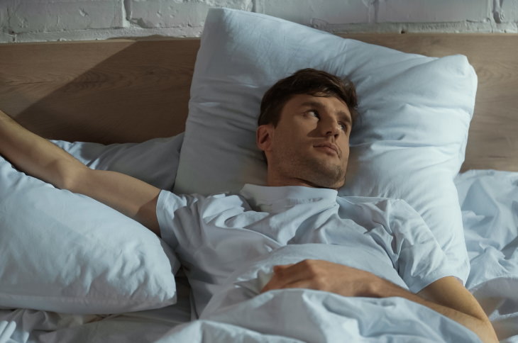 Exploding Head Syndrome men with insomnia lying in bed 