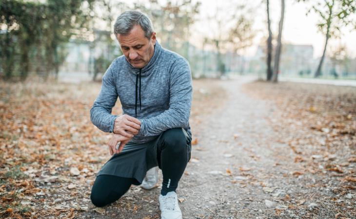 seniors exercise - checking pulse while jogging