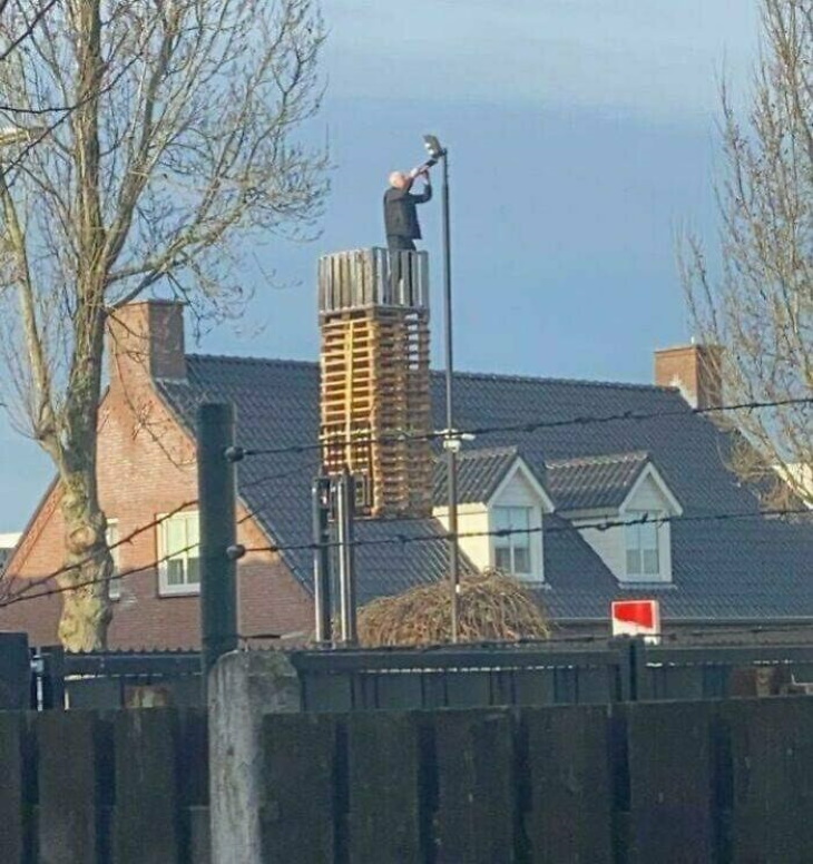 Work Safety Fails Just a man on a stack of pallets raised by a forklift changing the bulb on a street light.
