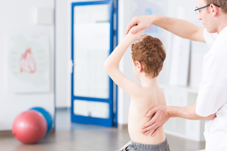 Types of Scoliosis boy examined by physical therapist