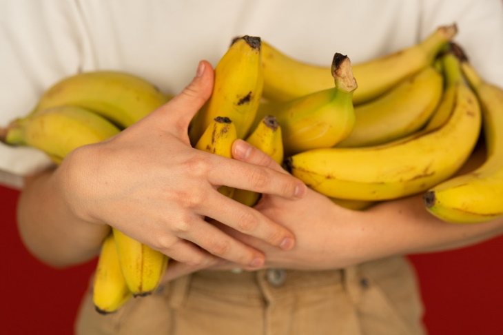 Banana Peel Flour holding a bunch of bananas