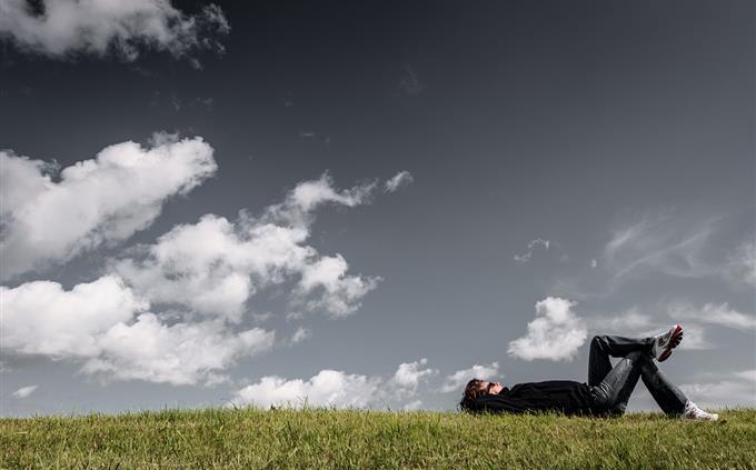 Picture and stress test: a calm young man lying on the grass