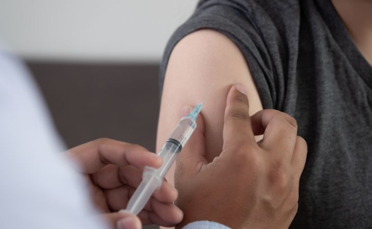 השלב השלישי במחקר החיסון נגד סרטן העור: איש מקבל חיסון ביד