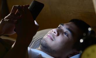 What the morning routine reveals about the personality: a man in bed with a phone