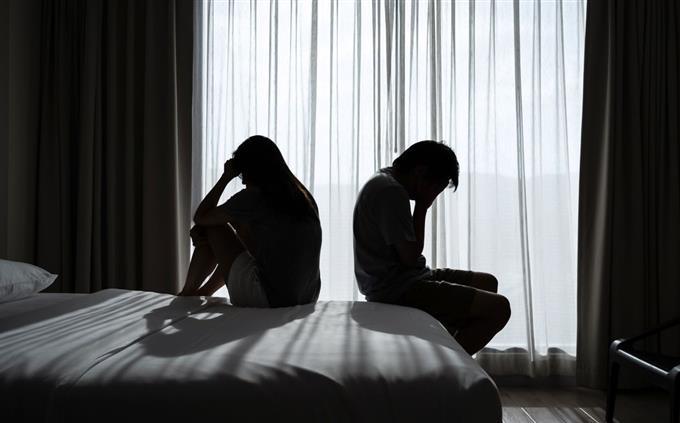Toxic Relationship Test: A man and a woman on a bed with their backs to each other