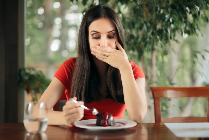  MedicalTerms For Bodily Functions Woman covering her mouth while eating