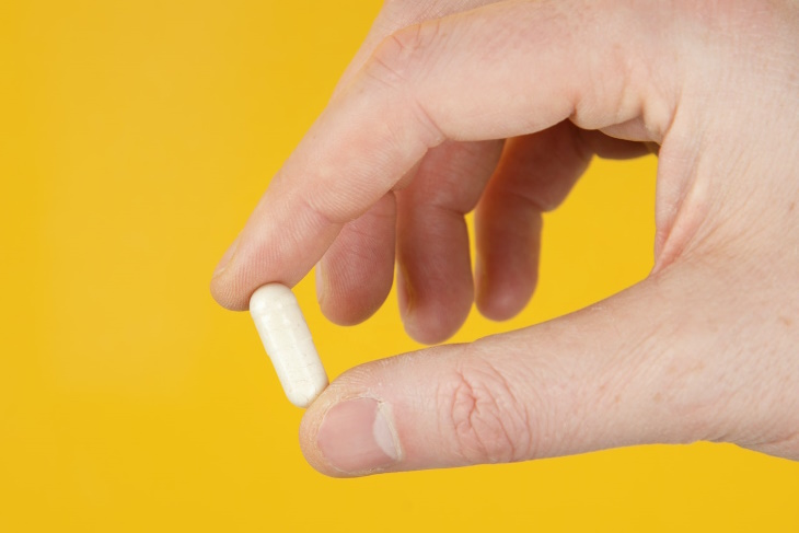 Probiotics hand holding a pill