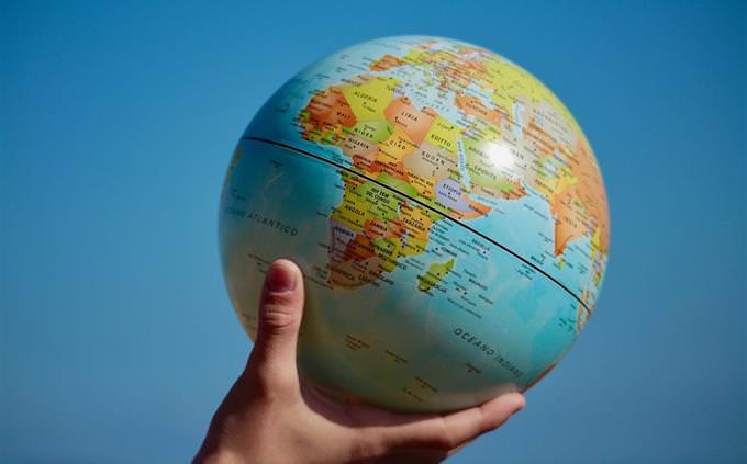 True False Test on World Geography: A hand holding a globe