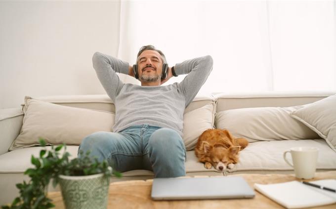 What your sleeping habits reveal about your future: A man on a sofa with a dog