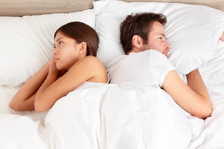 couple sleeping with their back to each other