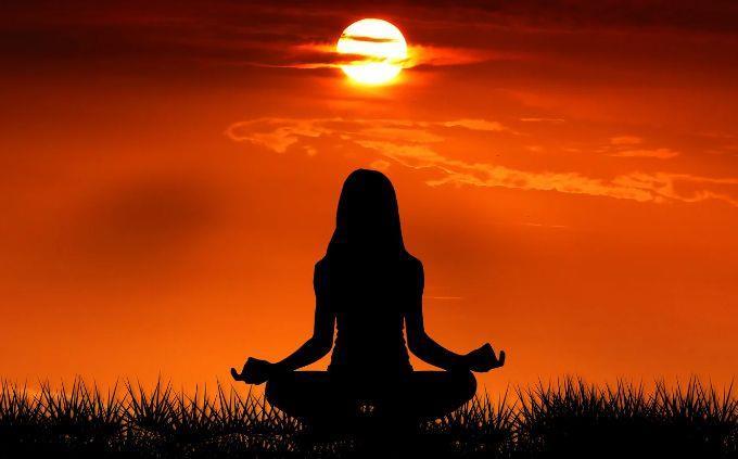 What garden hides in your soul: a woman meditating at sunset