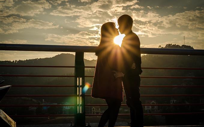 Personality test in a relationship: a couple kissing at sunset