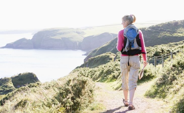 Mistakes you'll regret in the future: woman walking along a trail by the sea