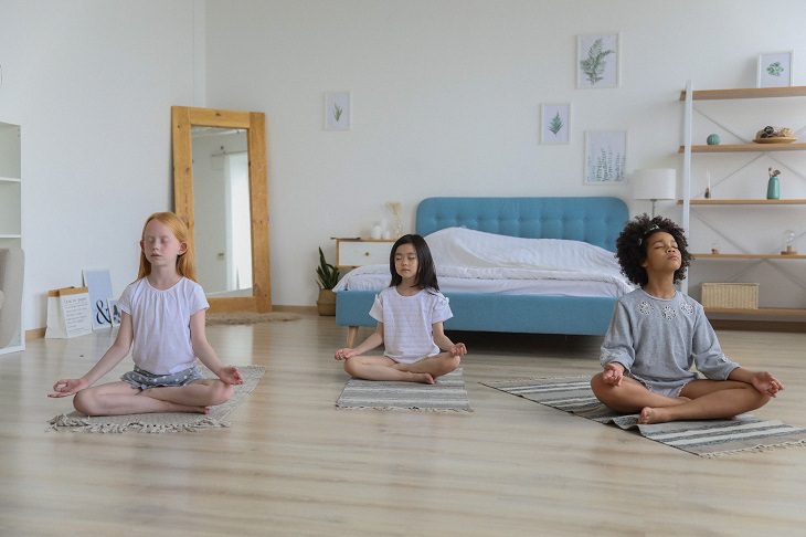 Meditation with kids: 3 girls doing seated yoga