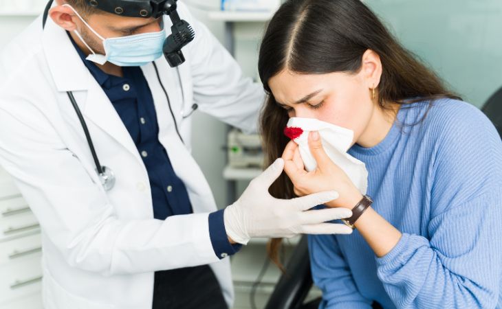 Causes, Treatment, and Prevention for Nosebleeds: Woman Bleeding from the Nose at the Doctor's