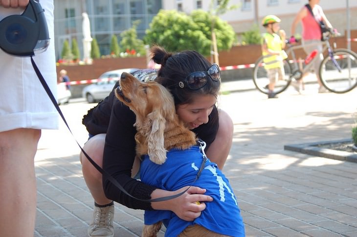 Signs your dog loves you: Woman hugging a dog